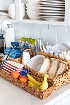 a wicker basket filled with dishes and fruit on top of a kitchen countertop