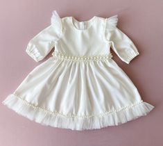 Baptism dress for baby girl with pearls. The colour of this dress is ivory.  There are tulle ruffles on the shoulders and pearl belt on the waist. Fabric-natural cotton.  The price is only for the dress.  We can sew matching booties, bloomers, headband with the same lace as on the dress. headband: https://www.etsy.com/listing/1277763367/pearl-headband-baby-girl-flower-girl?click_key=9393e6bb703f386c0c50cd01bd709eaa8bb3fb9f%3A1277763367&click_sum=d890857f&ref=shop_home_active_23&frs=1&sts=1 Booties: https://www.etsy.com/listing/1289288259/booties-with-pearls-for-baby-girl?click_key=113a40180a248241c7aecfc9d3b7cb88de5f260b%3A1289288259&click_sum=44c05677&ref=shop_home_active_1&frs=1&sts=1 bloomers: https://www.etsy.com/listing/1289301209/baptism-bloomers-baby-girl-bloomers?click_key=1b9d14d9 Christening Dress Baby Girl, Girls Baptism Dress, Baptism Dress Baby Girl, Baby Girl Baptism, Baby Girl Winter, Baptism Outfit, Baptism Dress, Christening Dress, Baby Bloomers