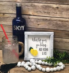 there is a mason jar with some lemons on it next to a sign that says when life gives you lemons, add vodka and ice