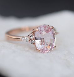 an oval shaped pink sapphire and diamond ring