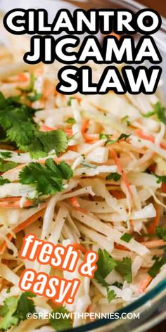 a glass bowl filled with shredded carrots and cilantro jicama slaw