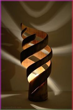 a lamp that is made out of wood and has a spiral design on the side