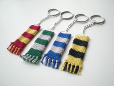 four knitted keychains with tassels on them sitting next to each other