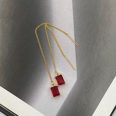 These Ruby Red Teardrop Crystal Thread Earrings are a dazzling combination of elegance and simplicity. Featuring striking ruby red teardrop crystals delicately suspended from slender chains, they provide an eye-catching pop of color and a subtle sparkle. Perfect for any occasion, they effortlessly enhance both casual and formal looks with their timeless appeal. Measurements: The total length from the top of the hook to bottom - 3.74 inches (95 mm) approximately. Crystals: 8 mm x 5 mm These earri Elegant Red Crystal Earrings, Elegant Red Drop Crystal Earrings, Elegant Red Drop Earrings, Elegant Red Earrings With Ear Wire, Minimalist Red Jewelry For Party, Minimalist Red Party Jewelry, Red Minimalist Dangle Earrings, Thread Earrings, Ruby Earrings