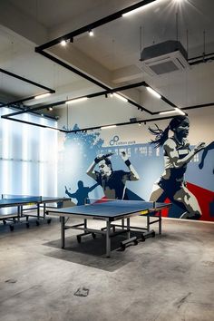 an indoor ping pong table with two ping pong tables in front of it