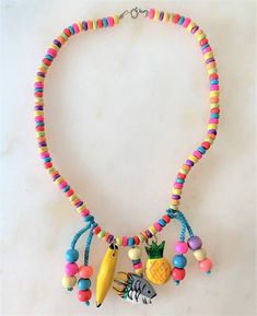 "Kids 15\" Brite Multi Colored Coco Beads Necklace with Hand Painted Wooden Charms & Beads Brite Multi Coco Chips Necklace Hand Painted Wooden Fish, Pineapple & Banana Charms Turquoise Cord with Multi Colored Wooden Beads Wooden Charms Hang Approx 1 1/2\" Long Silver Tone Spring Ring Clasp Made in the Philippines COMPLIMENTARY DOMESTIC SHIPPING" Playful Adjustable Necklaces For The Beach, Fun Beaded Adjustable Necklace, Fun Beaded Adjustable Necklaces, Playful Beaded Necklaces For The Beach, Adjustable Fun Necklace With Round Beads, Playful Beaded Necklace For The Beach, Adjustable Playful Beaded Necklaces For Festivals, Playful Beaded Necklace For Beach, Adjustable Playful Beaded Necklace For Festival