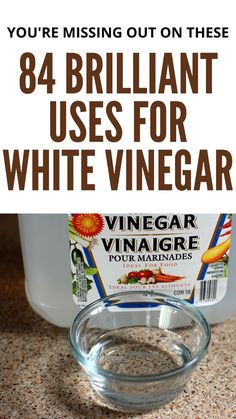 a bottle of vinegar sitting on top of a counter next to a glass bowl filled with liquid