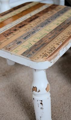 an old wooden table has been painted with different colors and words on the top, along with rusted paint