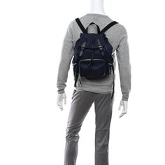 a mannequin with a backpack on it's back and grey pants,