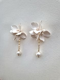 Delicate handmade 'Lucy' flowers arranged into beautiful cluster earrings with a dangling freshwater baroque pearl will make your bridal look extra special. Each flower is adorned with nugget pearl and attached to gold-filled or sterling hook earrings and gold filled or sterling silver chain. The total length of the earring is 4.5cm. Sent beautifully packaged in a Medze Bride gift box. As 'LUCY' earrings are made to order especially for you as well due to hygienic reasons I cannot accept refunds Handmade Bridal Earrings, Diy Bridal Earrings, White 14k Gold Filled Bridal Earrings As Gift, 14k Gold Filled White Bridal Earrings As Gift, Elegant 14k Gold-filled Flower Earrings, Elegant 14k Gold Filled Flower Earrings, Delicate White 14k Gold Filled Earrings, White 14k Gold-filled Pearl Earrings For Wedding, White 14k Gold Filled Pearl Earrings For Wedding