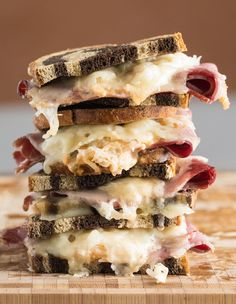 three sandwiches stacked on top of each other with meat and cheese in between the two halves