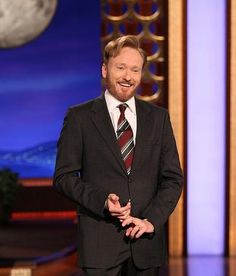 a man in a suit and tie standing on stage