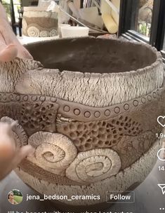 someone is working on a vase in the process of making it look like they have been carved