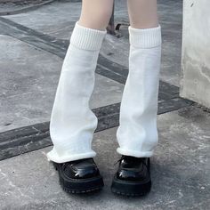 the legs of a woman wearing white socks and knee high socks with black shoes on them