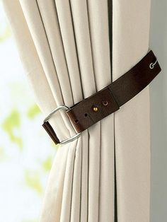 a close up of a curtain with a metal buckle on the end of it's belt