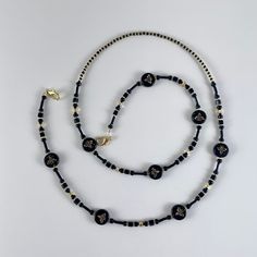 Each bead strand is created to hang comfortably around your neck and accessorize your outfit with style. Often used as eyeglass holders or badge holders, you can also wear solo as a necklace or hang other objects like pens or keys.  These bead strands run between 28"to 32" long, with durable metal lobster clasps on each end. They clip right onto a badge or you can add an extra attachment for eye glasses. We use both glass beads and natural stones that we string on a strong steel bead stringing wire. We double crimp the strand ends to make sure the beads are secure and durable to wear and enjoy everyday. How we make these... As we carefully lay out bags of all the beads, we look for big and small shapes that will complement one another in a pattern or design. With tweezers, we then lay out Black Glass Beaded Necklace With Beaded Chain, Beaded Lanyards Badge Holders, Black Beaded Glasses Chains, Black Beaded Lanyard, Adjustable Black Beaded Glasses Chains, Black Multi-strand Necklace With Faceted Beads, Tag Holder, Crimp Beads, Beaded Lanyards