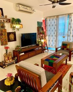 a living room filled with furniture and a flat screen tv sitting on top of a wooden stand