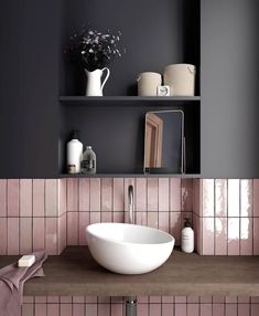 a white bowl sink sitting on top of a wooden counter next to a shelf filled with bottles