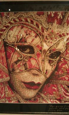 a painting of a woman's face in red, gold and white with beads