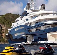 two jet skis are parked in front of a large yacht