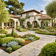 a large house with lots of trees and plants in front of the entrance to it