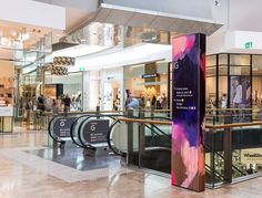 the inside of a shopping mall with people walking around and looking at items on display