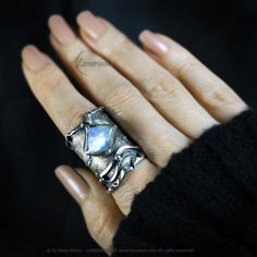 Modern, Brutalist-style Textured Ring. Fully handmade work.  Oxidized 925 Sterling Silver and Fine Silver. The main accent of this ring is a natural Rainbow Moonstone. Material: 925 Sterling Silver, Fine Silver, Rainbow Moonstone. The height of the central part is 3.1 cm. Size: Adjustable. Color: Silver, Blue. Fusion Style Moonstone Ring Gift, Fusion Style Moonstone Jewelry For Anniversary, Fusion Style Silver Moonstone Ring In Sterling Silver, Silver Sterling Moonstone Ring In Fusion Style, Handmade Opal Open Ring, Handmade Moonstone Open Opal Ring, Hand Forged Fusion Style Ring, Hand Forged Fusion Ring, Unique Hand Forged Open Moonstone Ring