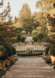 an outdoor ceremony setup in the middle of a garden with chairs set up on each side