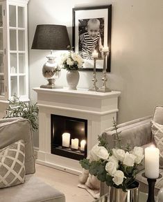 a living room filled with furniture and a fire place in front of a fireplace covered in candles