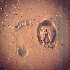 two footprints in the sand next to each other