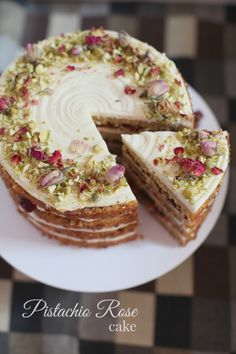 a cake with white frosting and flowers on it is sitting on a checkered tablecloth