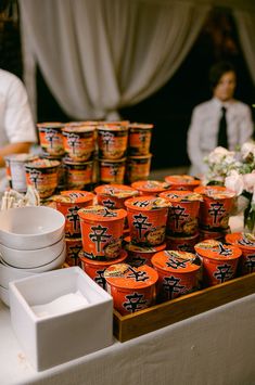 an assortment of yogurts are on display at a buffet table with people in the background