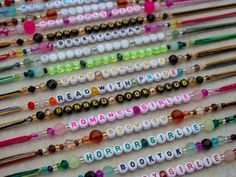 many different colored beads with words on them