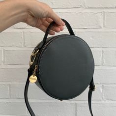 Merry Christmas from STUDIO TEW x Gorgeous, round leather grab bag. Hugely on trend this year! Other colours are available ABOUT THE GRACE BAG.. Double Zipped closure top  Grab handle  Removable long crossbody strap   Circular / round shape  Gold tone metal hardware  Handle max drop: 60 cm  Dimensions: H19cm x W19cm x D8cm  Material: Italian leather Handmade in Italy Dispatched in 1-3 working days from the UK. Leather Shoulder Bag With Detachable Handle In Round Shape, Leather Shoulder Bag With Detachable Handle And Round Case, Leather Shoulder Bag With Detachable Strap And Round Case, Round Case Bag With Detachable Handle, Trendy Round Case Shoulder Bag For Everyday, Everyday Round Case Shoulder Bag With Detachable Strap, Everyday Shoulder Bag With Detachable Strap And Round Case, Shoulder Bag With Detachable Handle For Daily Use, Leather Bag With Adjustable Strap And Round Case