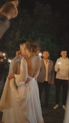 a bride and groom kissing in front of sparklers