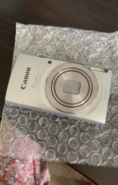 a silver camera sitting on top of a plastic bag