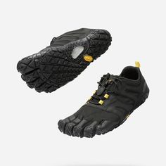 a pair of black shoes with yellow accents on the soles and bottom part of the shoe