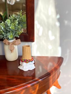 a table with a vase filled with flowers and a small hat on top of it