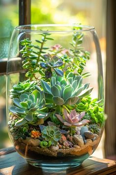 a glass vase filled with plants on top of a wooden table