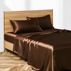 a bed with brown sheets and pillows on it