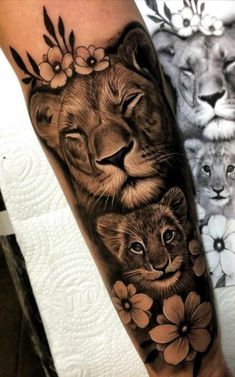 a lion and cub tattoo with flowers on the arm, done in black and white