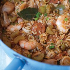 a blue pot filled with rice and shrimp