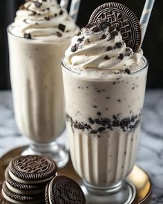 two glasses filled with ice cream and oreo cookies next to each other on a plate