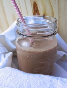 a glass jar filled with chocolate smoothie on top of a white towel