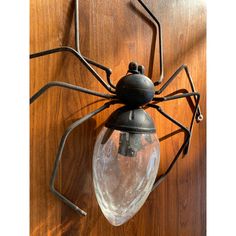 a spider lamp hanging from the side of a wooden wall