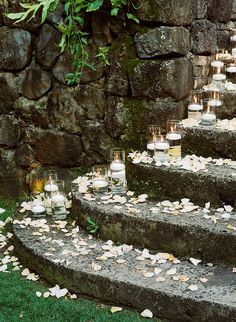 many candles are lit on the steps outside