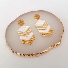 Modern hexagon earrings, with Miyuki beads in white and gold colors. Refined and very light to wear. Original and delicate stud earrings made with Miyuki beads and completely hand-woven by me. The base that holds the earring is in gold stainless steel. Features of the earrings are: Length: 4.8 cm Width: 2 cm Here you can see other designs of white, gold and silver earrings: https://www.etsy.com/shop/AQBijouterie?ref=seller-platform-mcnav&section_id=34429251   It will be a pleasure to answer you Gold And Silver Earrings, Hexagon Earrings, Schmuck Gold, Native American Crafts, Earrings Summer, Summer Earrings, Gold Stud Earrings, Summer Earring, Miyuki Beads