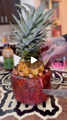 a person cutting up a pineapple on top of a table