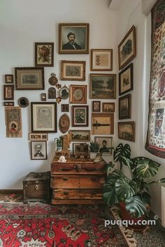 a room filled with lots of framed pictures on the wall next to a rug and potted plant