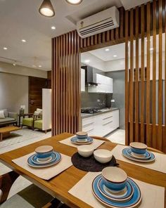 a dining room table with plates and bowls on it